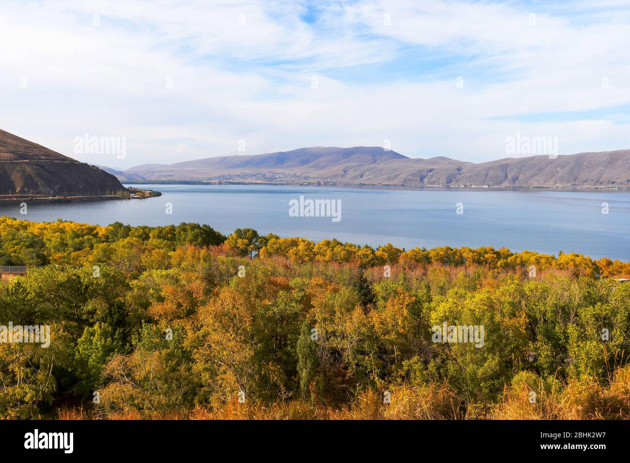 Sevan See in Armenien mit schönen Bäumen in Herbstfarben. Alpensee mit Bergen im Kaukasus. Beliebtes armenisches Reiseziel. Stockfoto