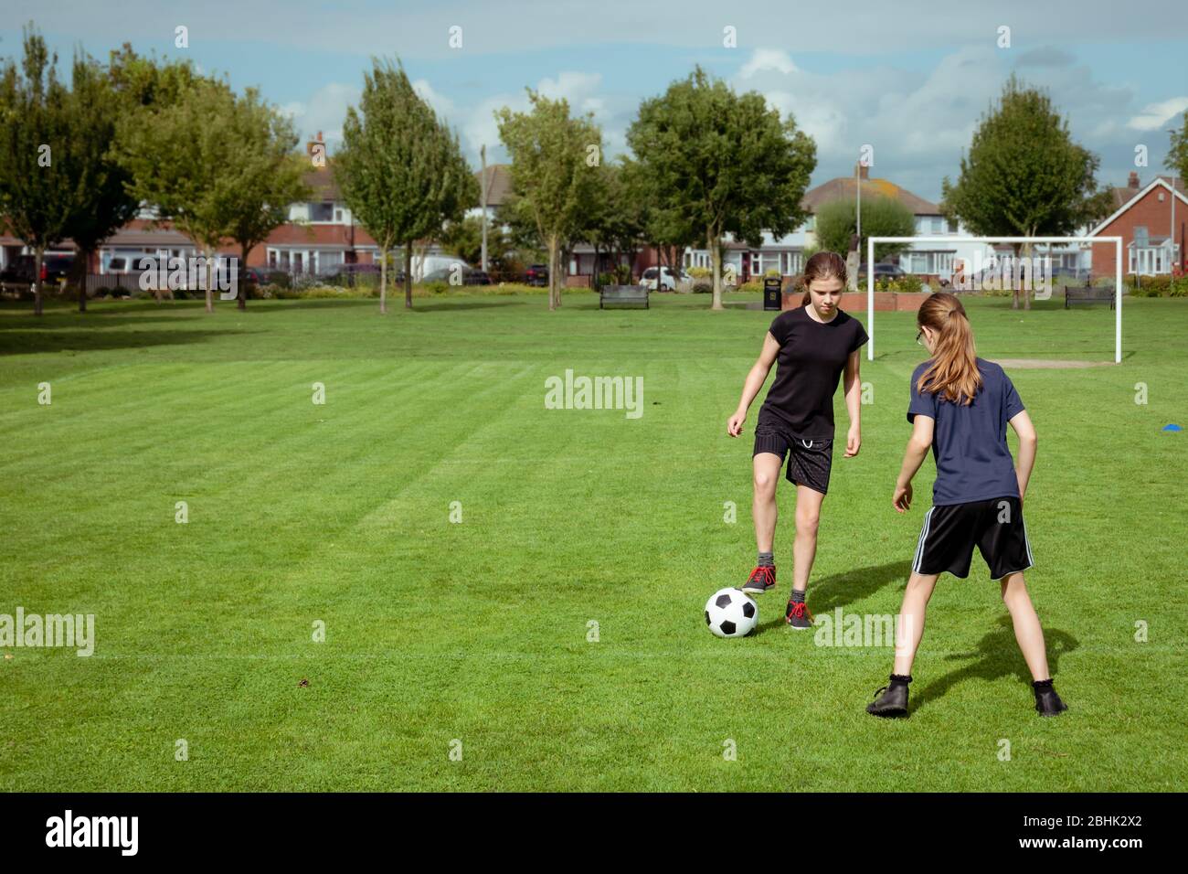 Mädchen üben und trainieren im Fußball in einem lokalen Gemeindepark Stockfoto