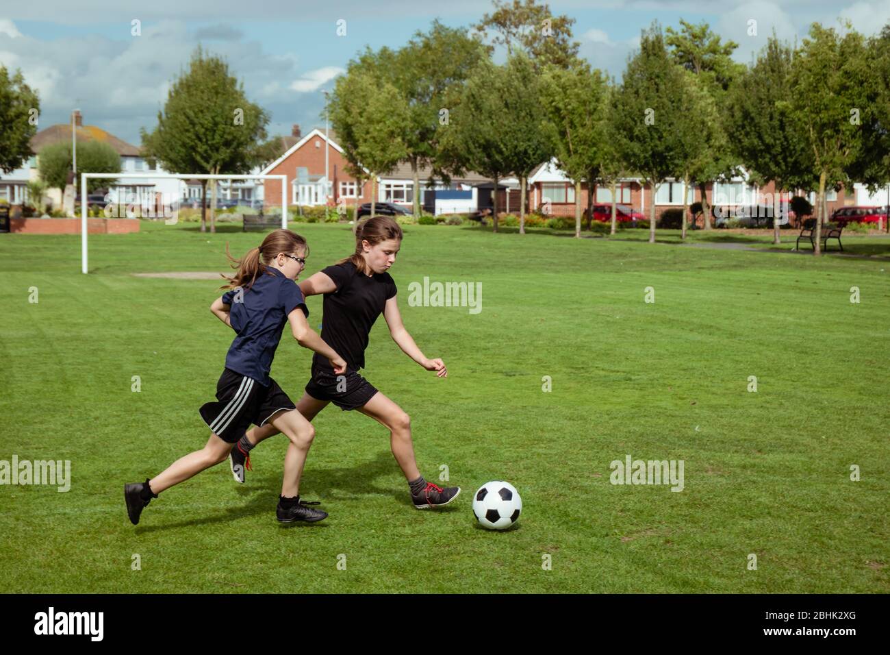 Mädchen üben und trainieren im Fußball in einem lokalen Gemeindepark Stockfoto