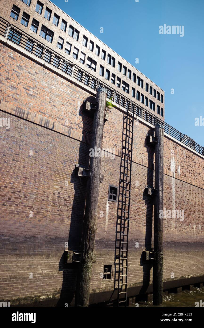 Holzmacherpfosten und Leiter in einem Kanal in Hamburg, neben Wand auf Stelzen Stockfoto