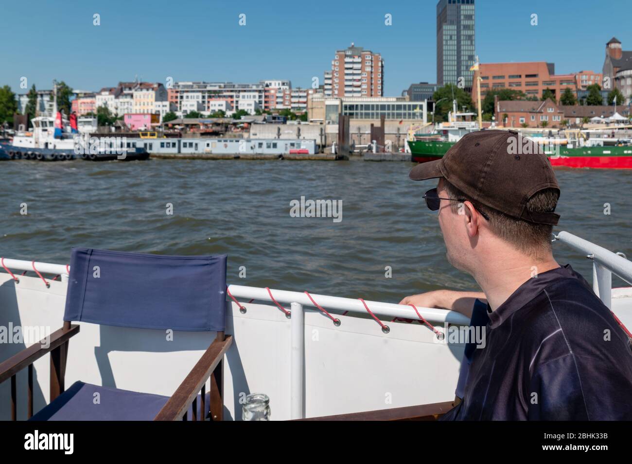 Ein männlicher Tourist auf einer Flusskreuzfahrt durch die Stadt und den Hafen von Hamburg Stockfoto