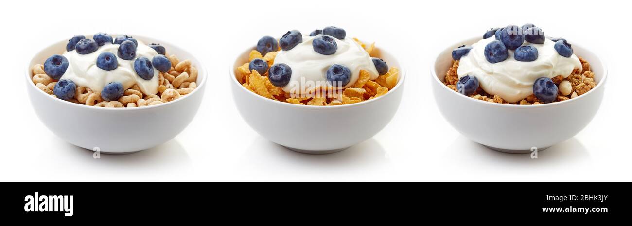 Drei Schüsseln aus verschiedenen Getreidearten mit Joghurt und frischen Blaubeeren auf weißem Hintergrund isoliert Stockfoto