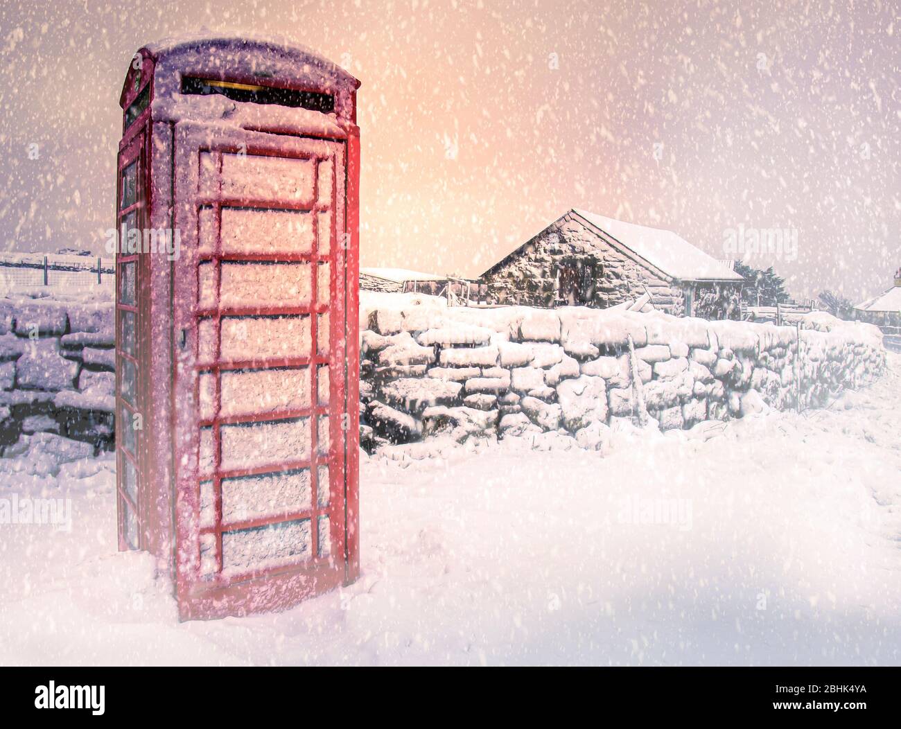 Traditionelle rote Telefonbox mit Schnee bedeckt, Dartmoor, Devon, UK, Stockfoto