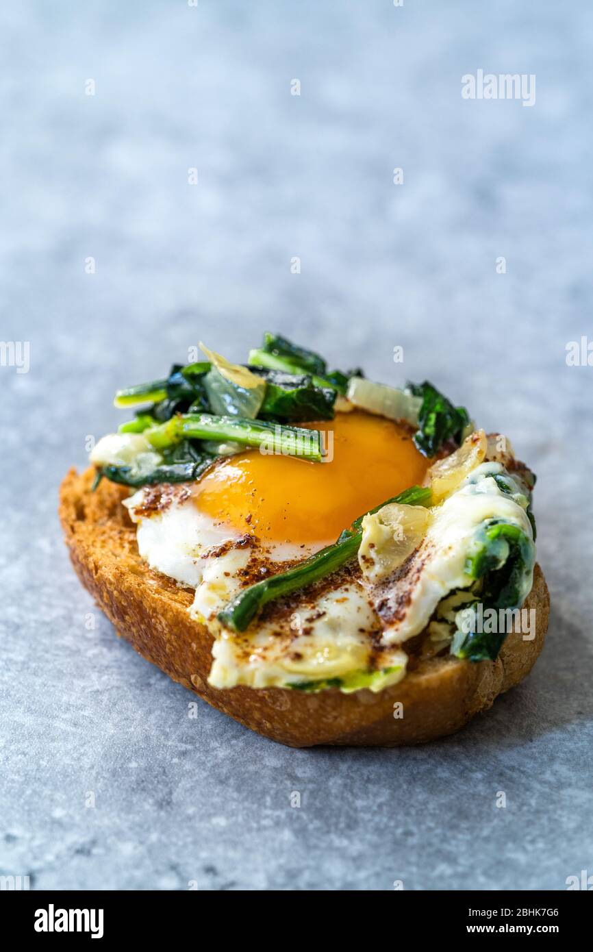 Gekochter Spinat mit gebratenen Eiern auf Toastbrot-Scheibe. Gesunde Bio-Lebensmittel. Stockfoto
