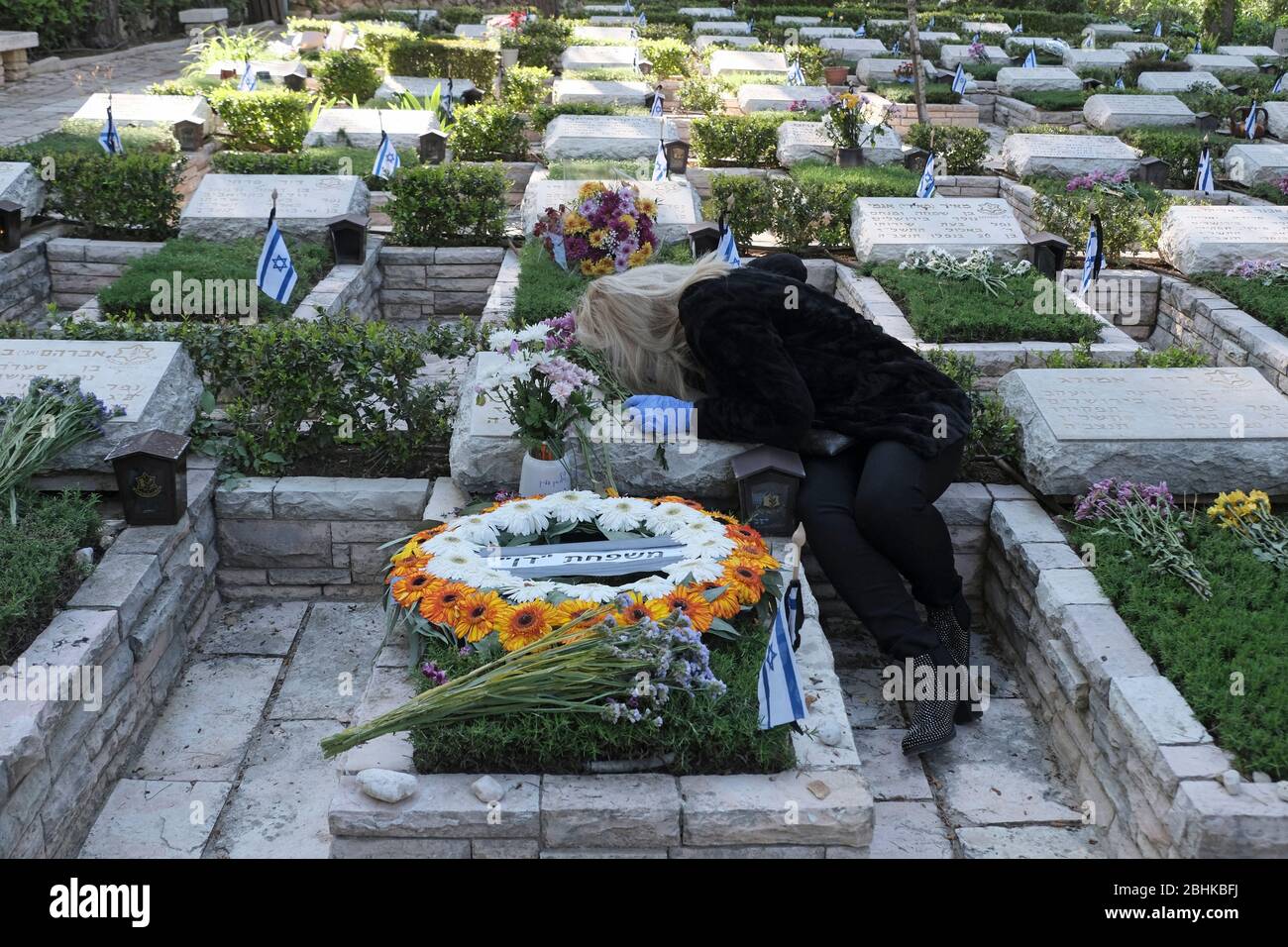 Jerusalem, Israel. April 2020. Eine israelische Frau trauert über dem Grab eines geliebten Menschen beim nationalen Militär in Mount Herzl in Jerusalem, während Israel sich auf den Gedenktag für gefallene Soldaten vorbereitet. Offizielle Zeremonien werden dieses Jahr nicht stattfinden, da eine nationale Ausgangssperre zur Bekämpfung der COVID-19-Pandemie aussteht. Stockfoto