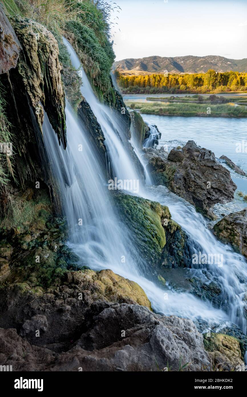 Herbstbäume säumen den Snake River hinter einem Wasserfall aus nächster Nähe Stockfoto