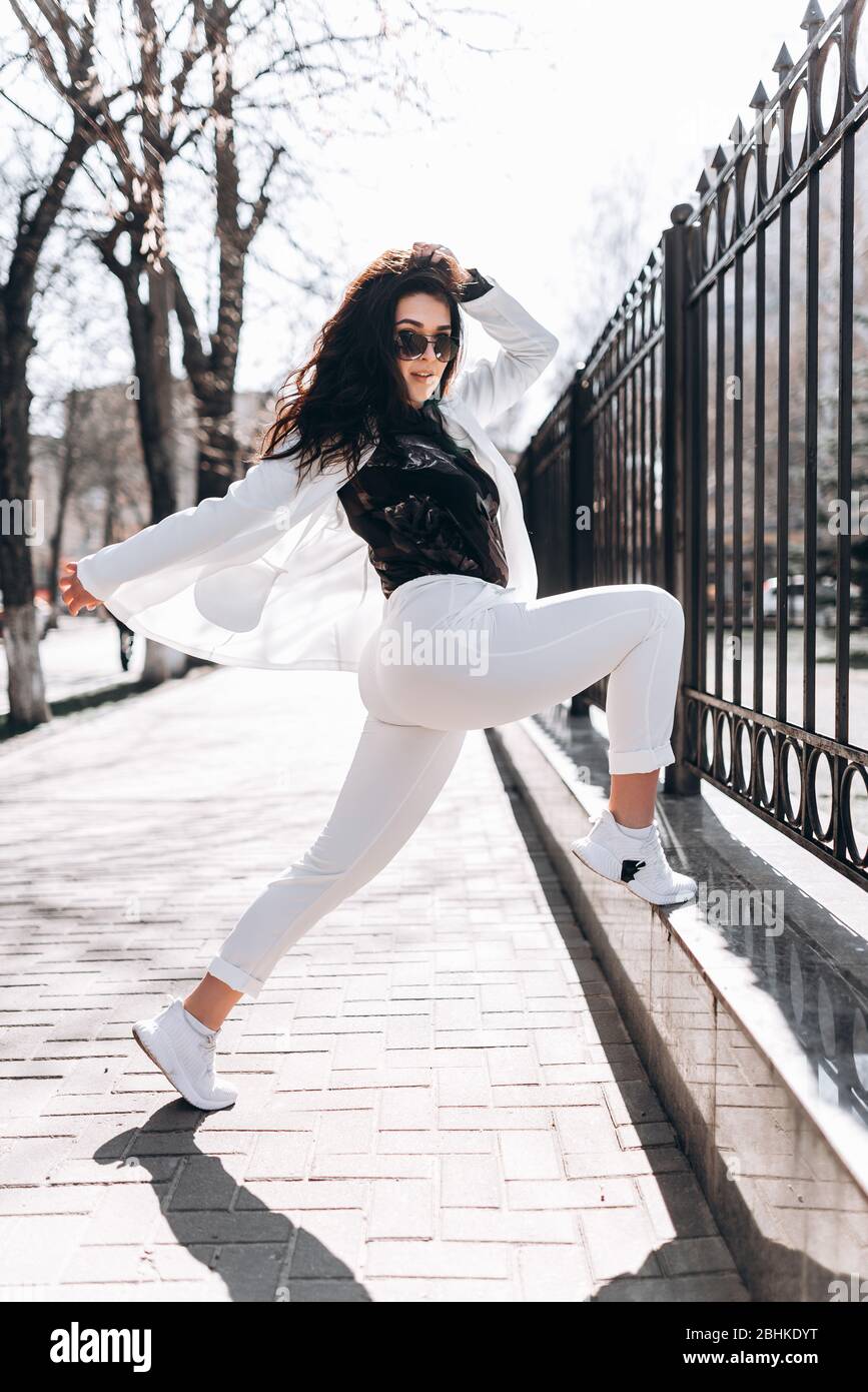 Mode-Porträt einer fröhlichen Frau eines jungen ziemlich trendy Mädchen posiert in der Stadt, Frühjahr Street Fashion. Stockfoto