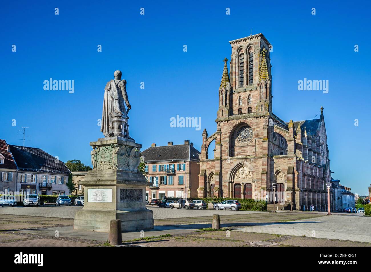 Statue von Phalsbourg Geboren Georges Mouton, comte de Lobau, auf dem Place d'Armes in Phalsbourg, vor dem Hintergrund der neugotischen Kirche unseres Knaben Stockfoto