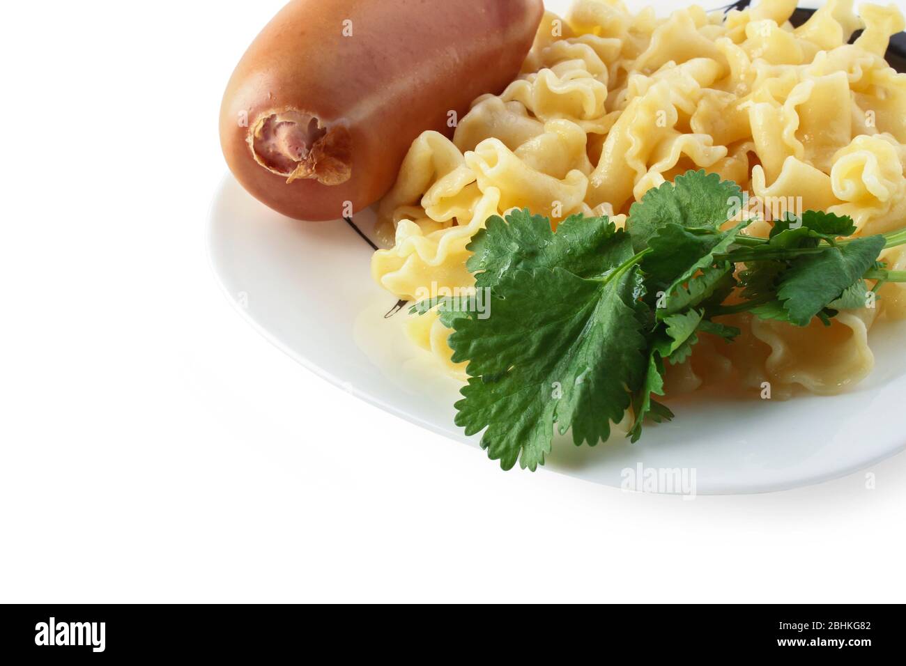 Vermicelli mit gekochter Wurst auf einem Teller, dekoriert mit einem Bündel Koriander Stockfoto