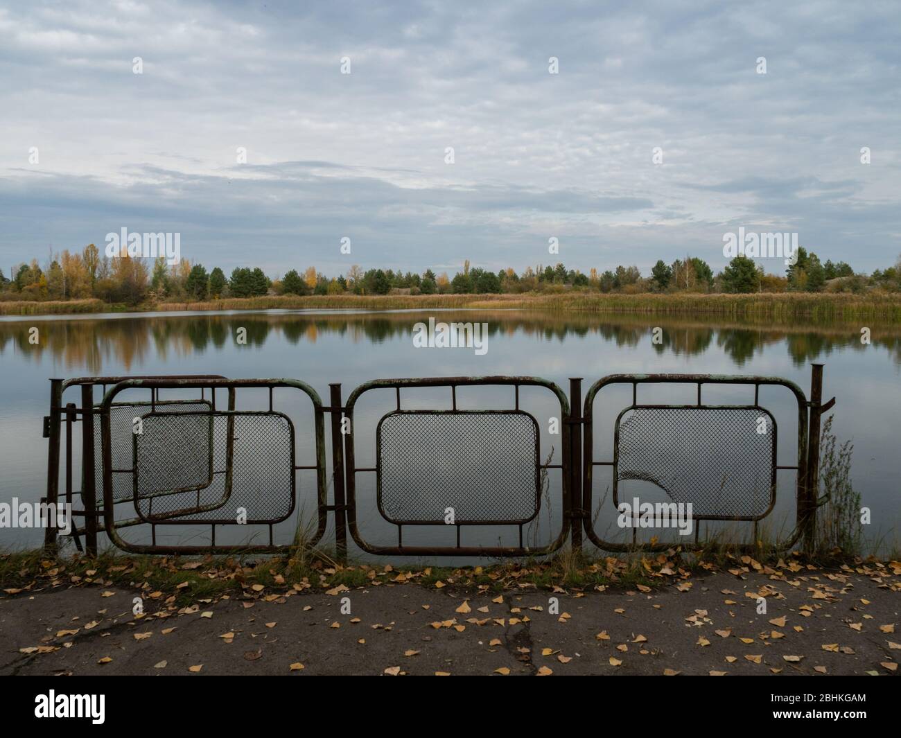 Herbstlandschaft Fluss und Eisenzaun in Pripjat, Tschernobyl-Ausschlusszone in der Ukraine Stockfoto