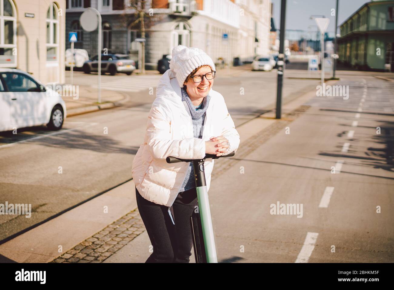 Tourist Frau mieten Elektroroller in der dänischen Hauptstadt Kopenhagen. Weibliche Lenksäulenknopf mit elektrischem Kick Scooter Griff auf der Straße in Stockfoto