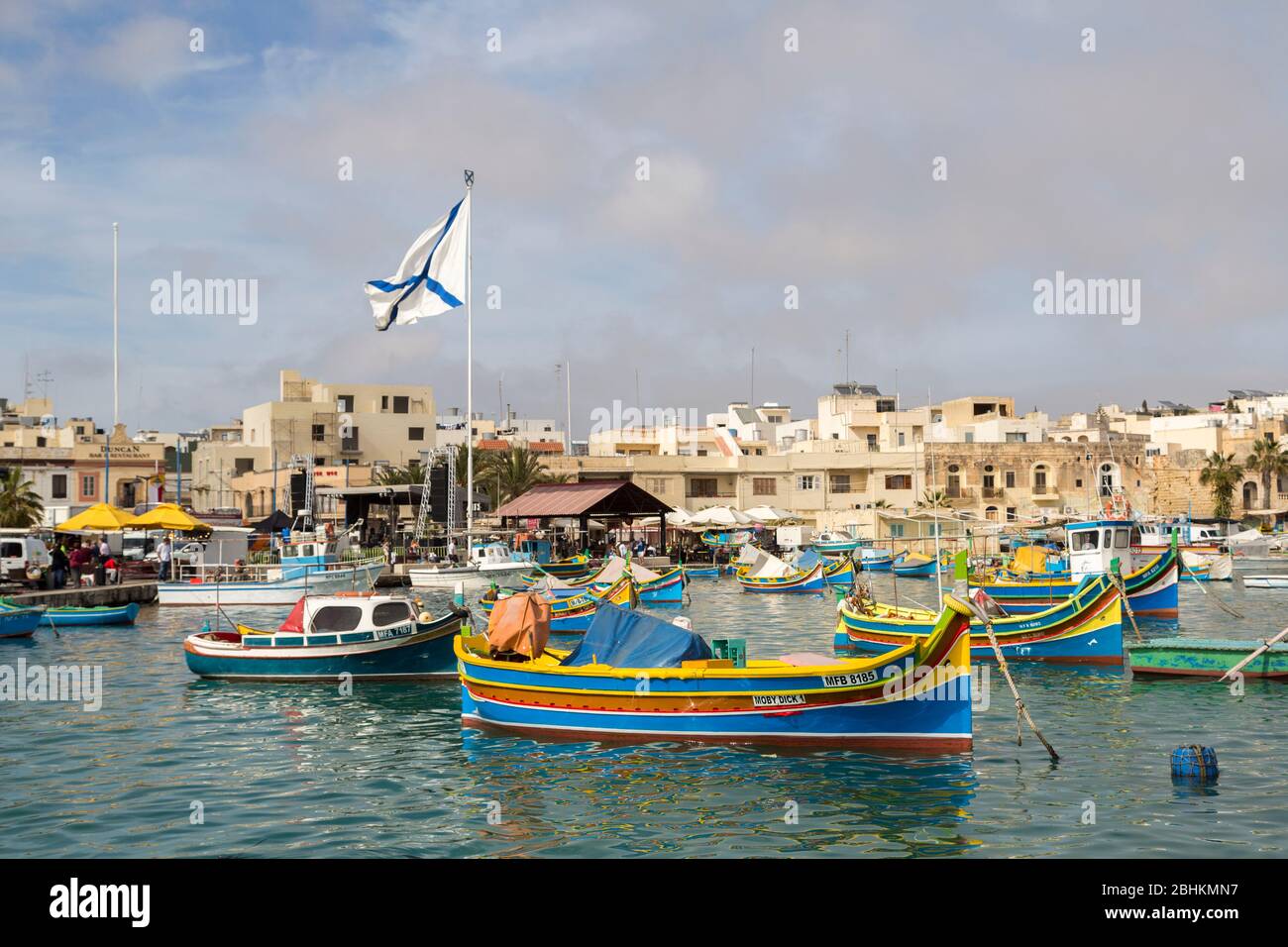 Hafen mit Booten und maltesischer Flagge in Marsaxlokk, Malta Stockfoto