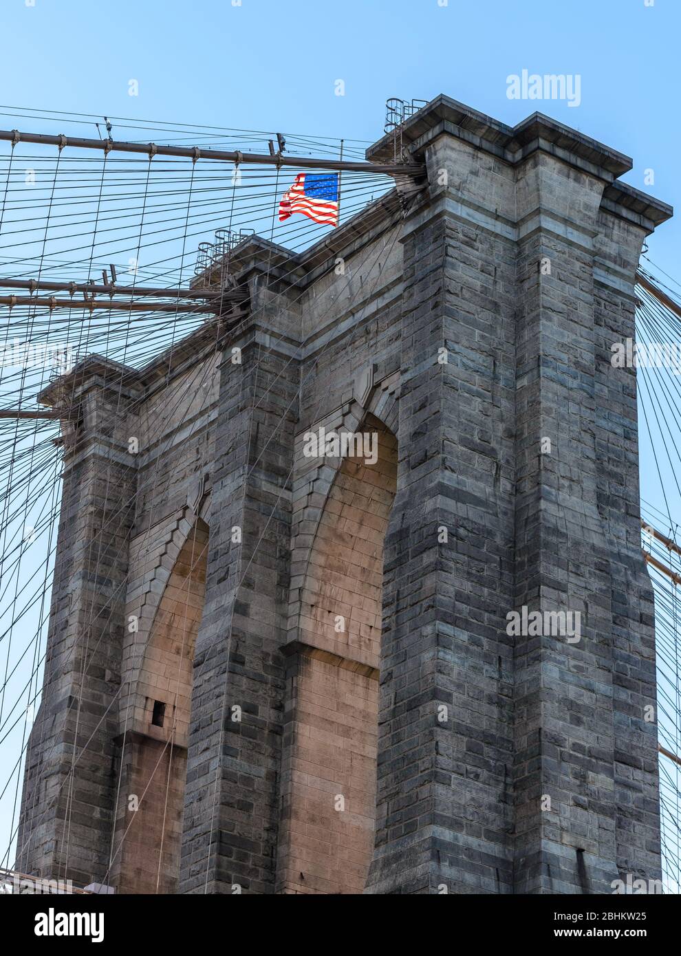 Brooklyn Bridge mit amerikanischer Flagge auf der Oberseite, Nahaufnahme mit Bögen. Stockfoto