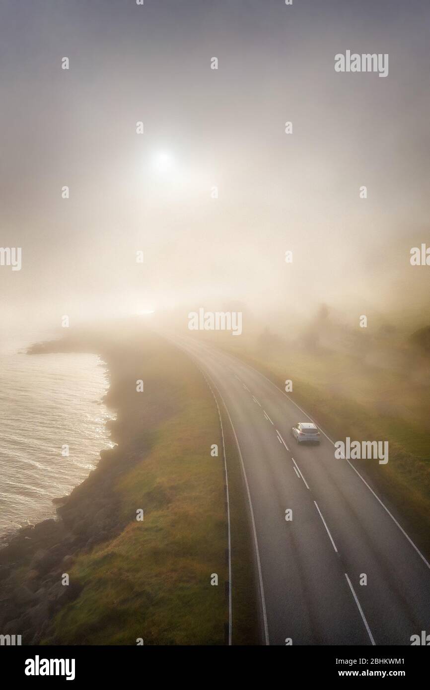 Neblige Straße in die niedrige Sonne auf den Färöern, nachbearbeitet in HDR Stockfoto