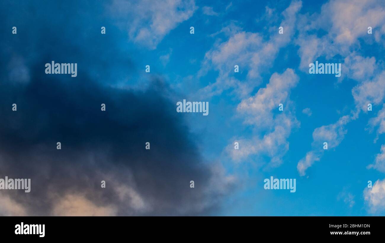 Eine Sturmwolke greift auf den blauen Himmel über, wenn sich das turbulente Wetter nähert. Stockfoto