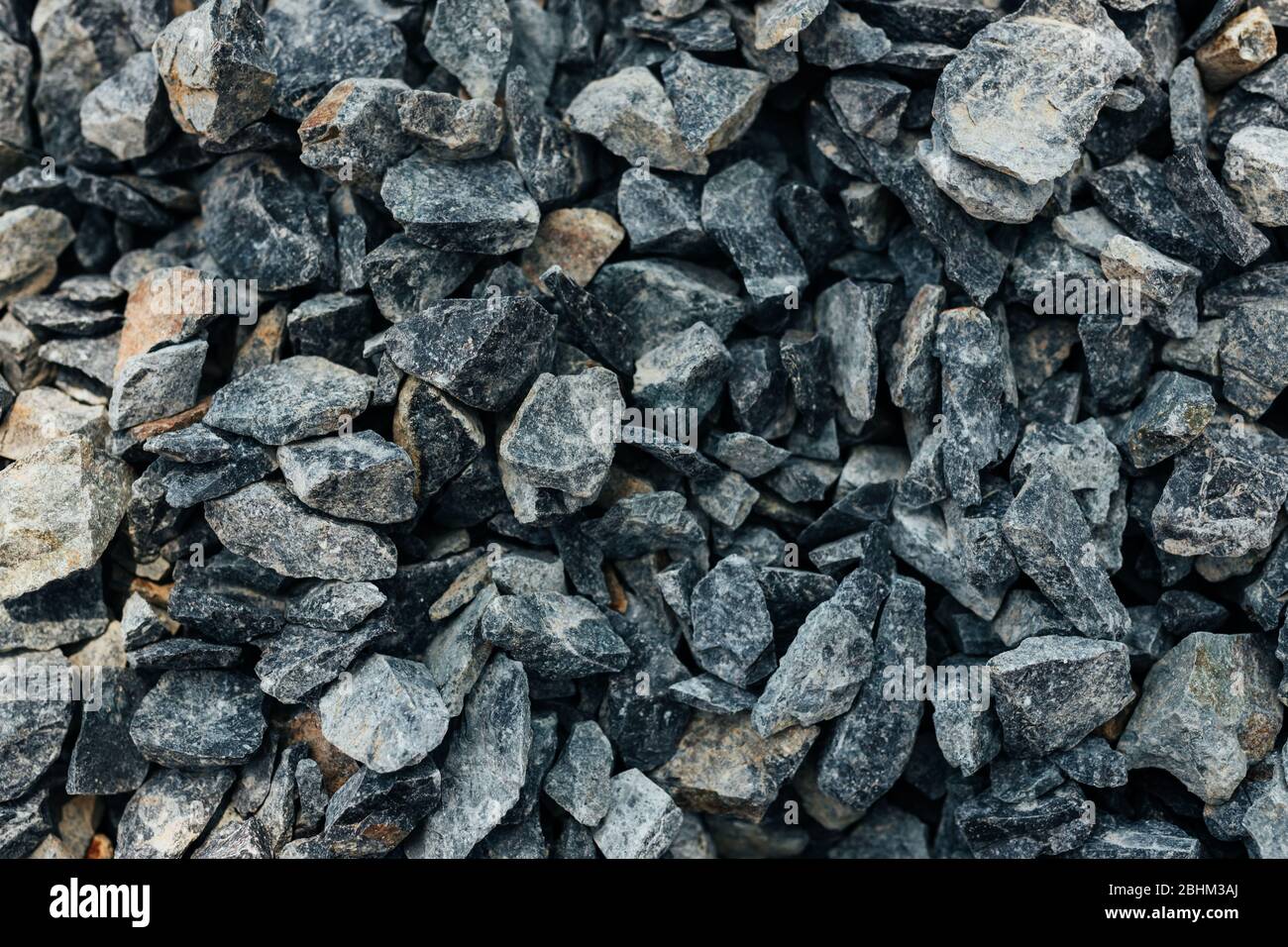 Grobe Steine, Schotter, Granitkies Nahaufnahme. Die raue Textur des Steins. Hintergrund des Baumaterials. Struktur Stockfoto