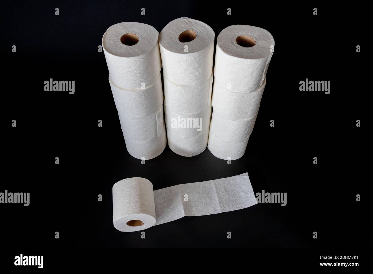 Stapel von weißem Toilettenpapier isoliert auf schwarzem Hintergrund. Stockfoto