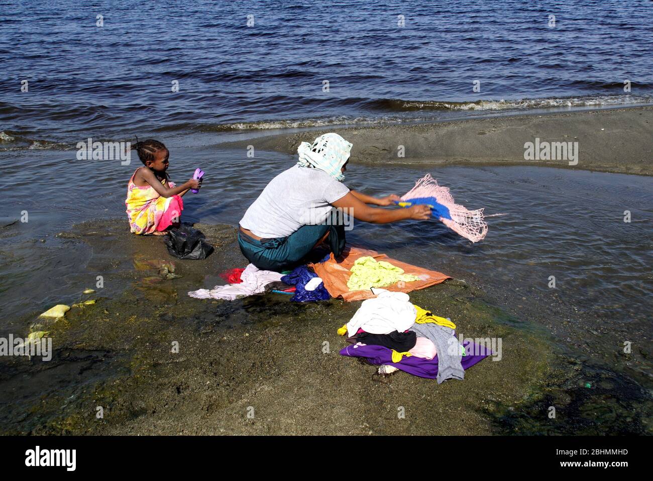 Mutter und Tochter waschen Kleidung an den Ufern des Lake Abijatta Stockfoto