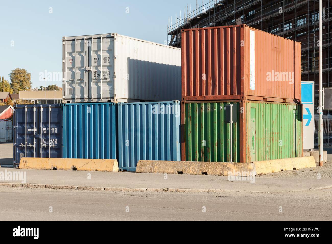 Gestapelte Gruppe von Frachtcontainern ist in einem Hafenviertel, moderne industrielle Schifffahrtsausrüstung Stockfoto