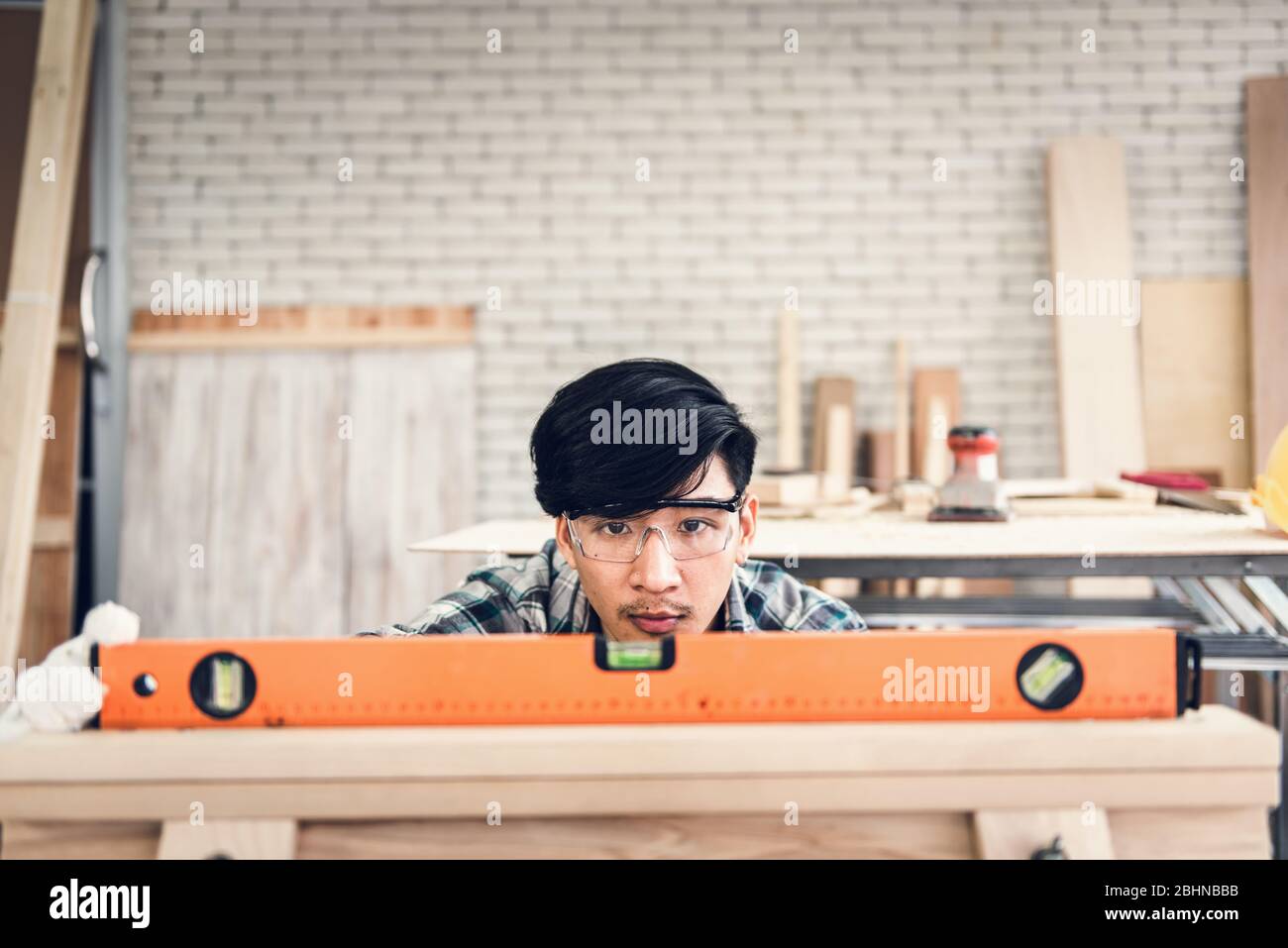 Zimmermann man arbeitet Holzholzbearbeitung in der Tischlerei, Handwerker ist Nivellierung Holzplanke für Holzmöbel in der Werkstatt. Workmans Stockfoto