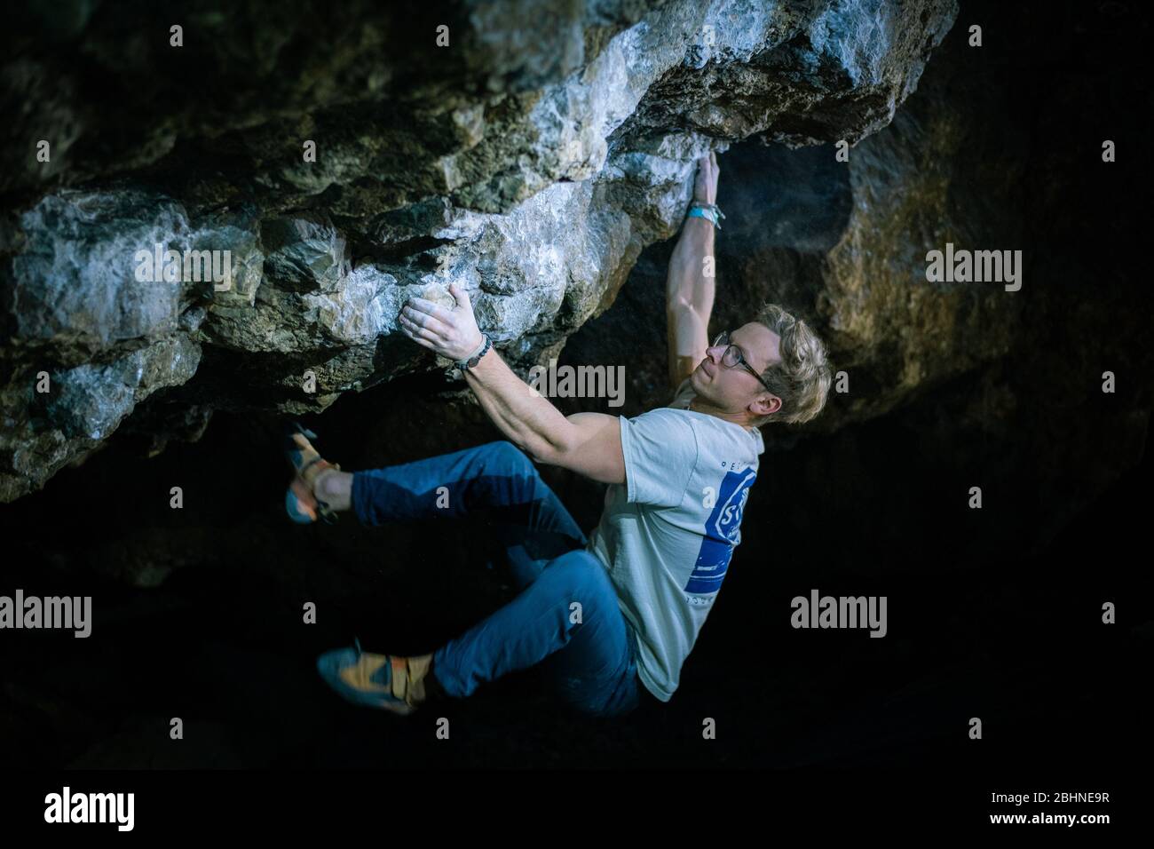 Der Mensch macht einen Felsbrocken in der Twardowski Höhle. Bouldern im Fels. Twardowski Höhle Stockfoto