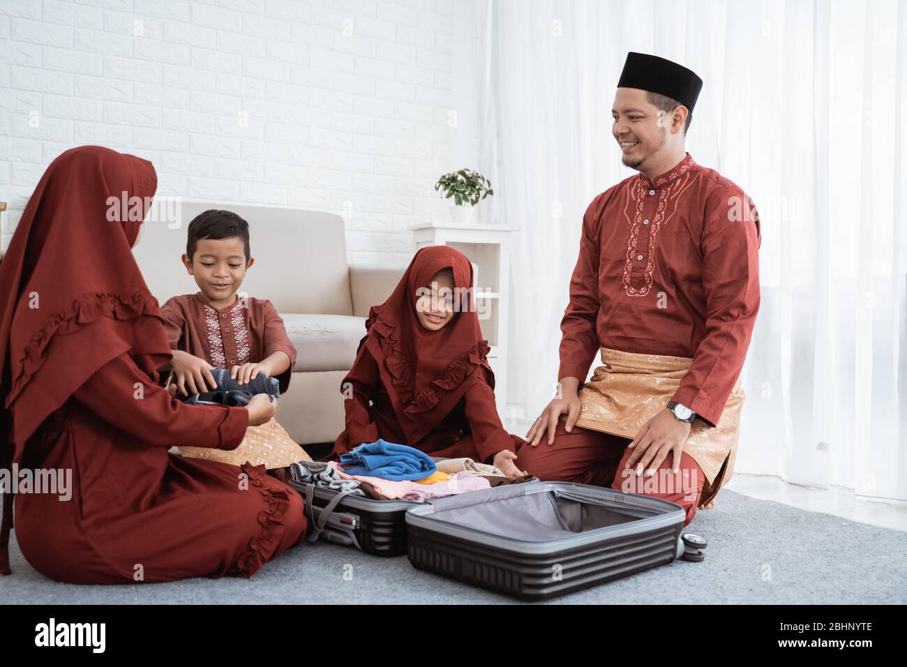 Asiatische Familie bereiten Kleidung und legte in einem Koffer, um Mudik in die Heimatstadt gebracht werden Stockfoto Asiatische Familie bereiten Kleidung und legte in einem Koffer, um Mudik in die Heimatstadt gebracht werden Stockfoto