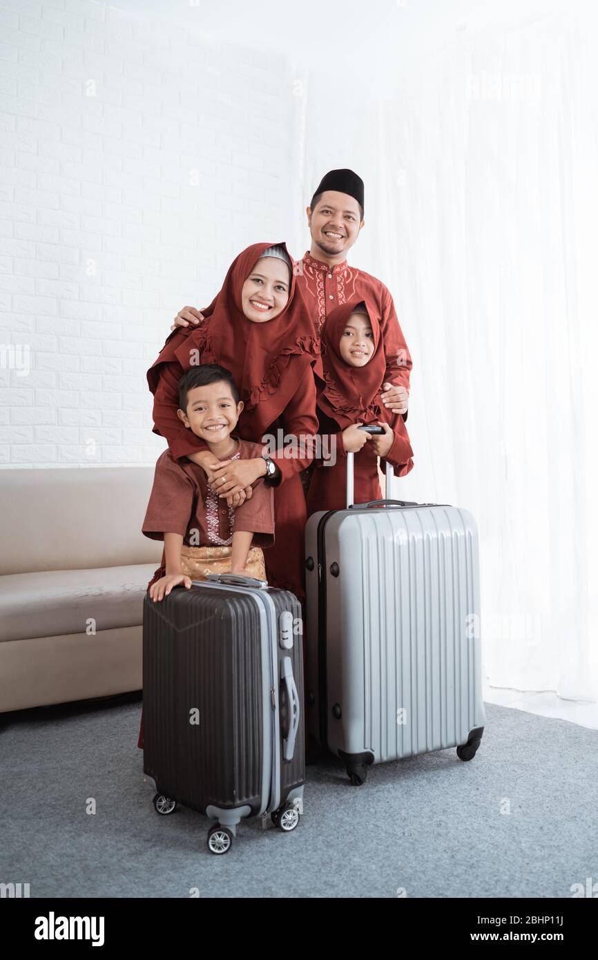 Asiatische Familie mit Tochter und Sohn mit Koffern bereit, mudik in ihre Heimatstadt Stockfoto Asiatische Familie mit Tochter und Sohn mit Koffern bereit, mudik in ihre Heimatstadt Stockfoto
