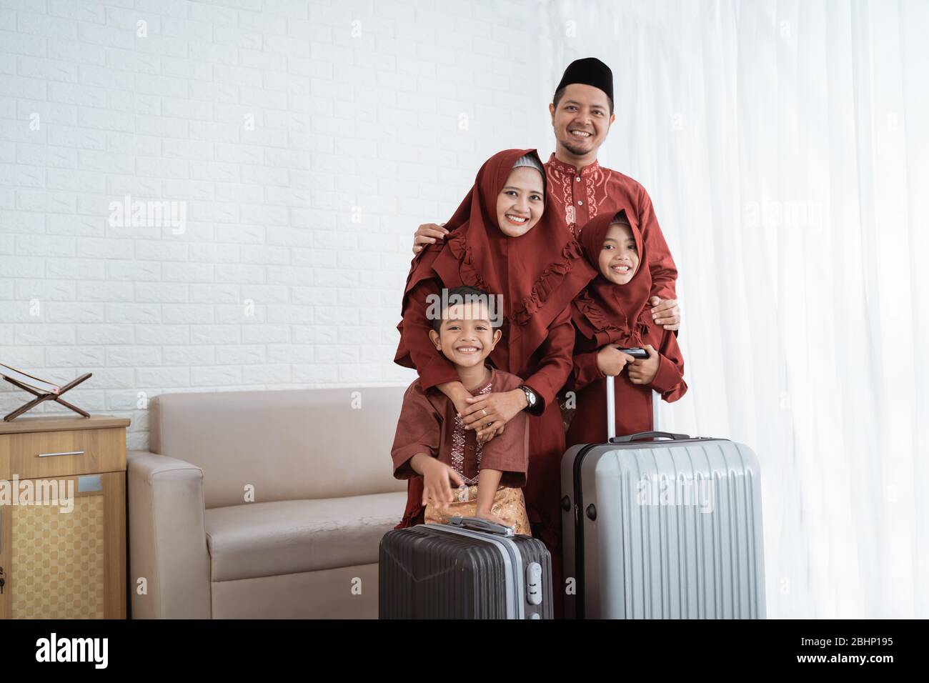 Asiatische muslimische Familie nach dem Packen Kleidung mit Koffern zu tragen mudik in ihre Heimatstadt Stockfoto Asiatische muslimische Familie nach dem Packen Kleidung mit Koffern zu tragen mudik in ihre Heimatstadt Stockfoto
