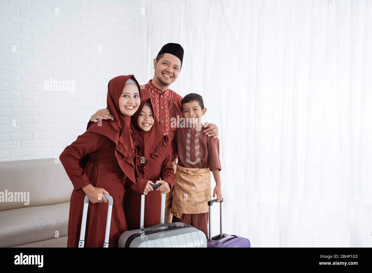 Asiatische muslimische Familie nach dem Packen Kleidung mit Koffern zu tragen mudik in ihre Heimatstadt Stockfoto Asiatische muslimische Familie nach dem Packen Kleidung mit Koffern zu tragen mudik in ihre Heimatstadt Stockfoto