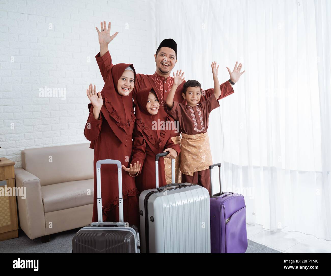 Familie mit Tochter und Sohn auf Wiedersehen Hände bis mit Koffern bereit, um mudik in ihre Heimatstadt Stockfoto Familie mit Tochter und Sohn auf Wiedersehen Hände bis mit Koffern bereit, um mudik in ihre Heimatstadt Stockfoto