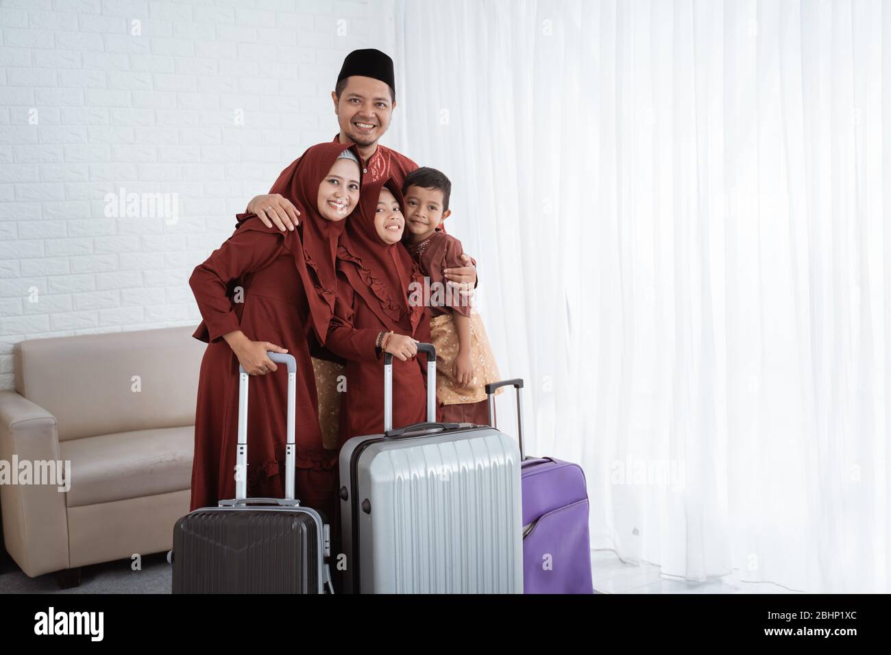 Asiatische muslimische Familie nach dem Packen Kleidung mit Koffern zu tragen mudik in ihre Heimatstadt Stockfoto Asiatische muslimische Familie nach dem Packen Kleidung mit Koffern zu tragen mudik in ihre Heimatstadt Stockfoto