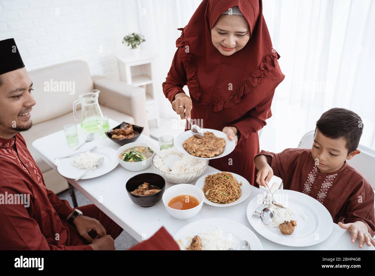 Muslimische Familie essen gerne, wenn das Fasten zu Hause gemeinsam bricht Stockfoto