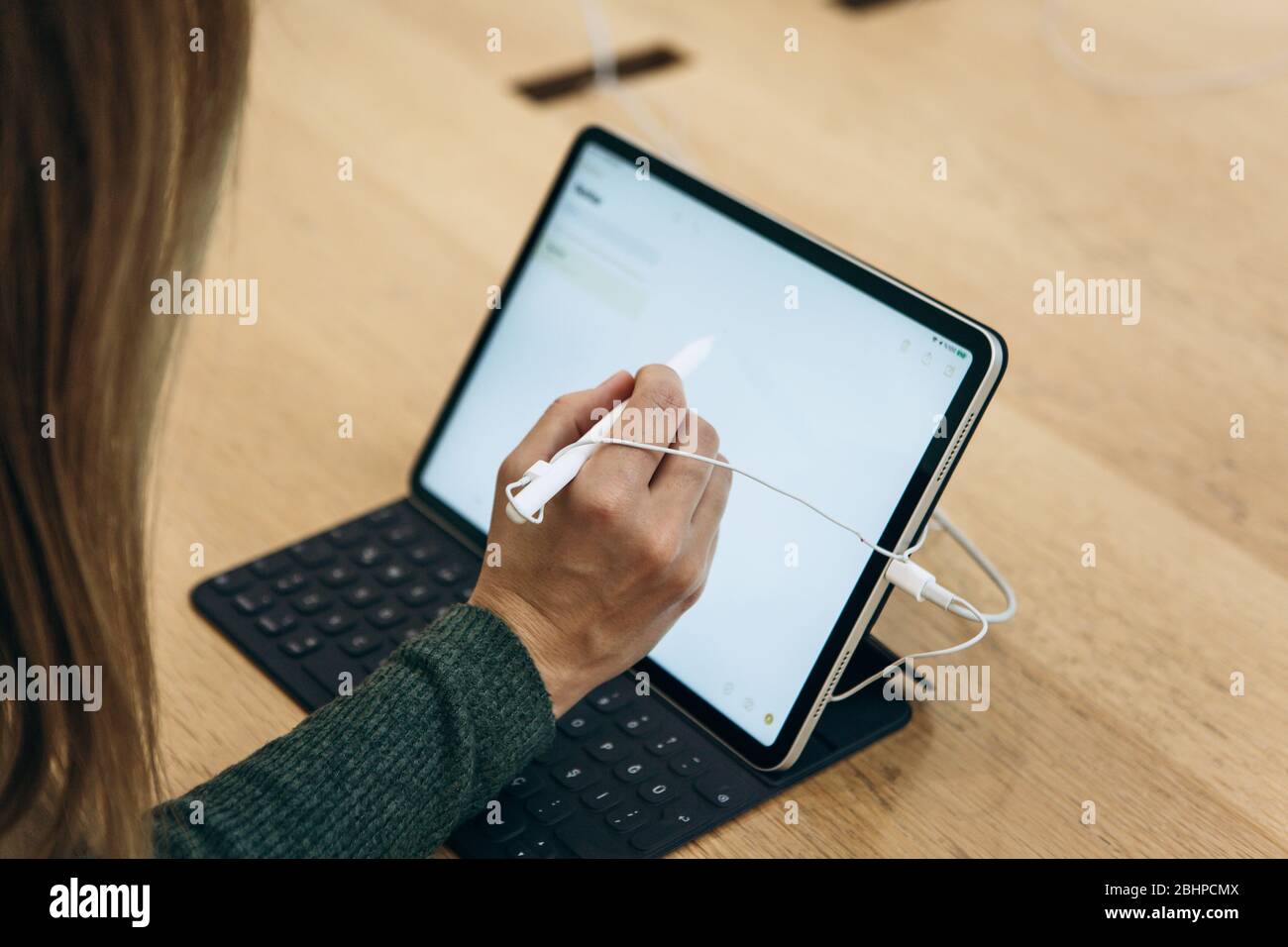 Türkei, Istanbul, 17. Dezember 2019: Verkauf Neues Tablet APPLE iPad im offiziellen Apple Store. Der Käufer versucht, eine einfache Zeichnung mit dem Stift auf dem Bildschirm des Gadgets zu zeichnen. Stockfoto