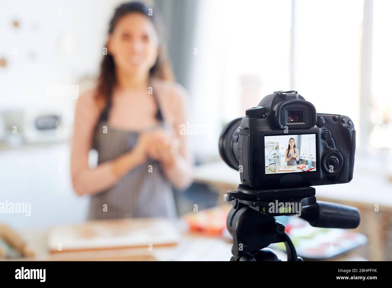 Junge Frau steht allein in ihrer Küche Shooting Bäckerei Tutorial für ihre Lebensmittel-Blog-Kanal Stockfoto