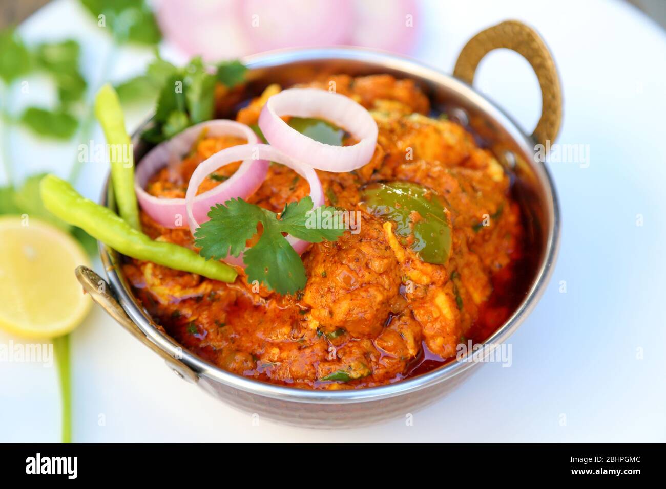 HÜTTENKÄSE IM INDISCHEN STIL VEGETARISCHES CURRY GERICHT. Kadai Paneer – traditionelle indische oder punjabi-Küche. Garniert mit Zwiebel- und Chilischeiben. Stockfoto