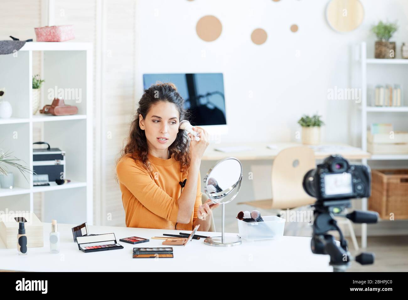 Junge Erwachsene kaukasische Frau tun Casual Make-up und Aufnahmeprozess vor der Kamera Stockfoto
