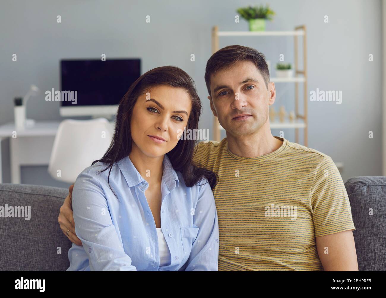 Ein Paar in einer ernsthaften emotionalen Stimmung mit Problemen schaut auf die Kamera, während es auf der Couch sitzt. Stockfoto