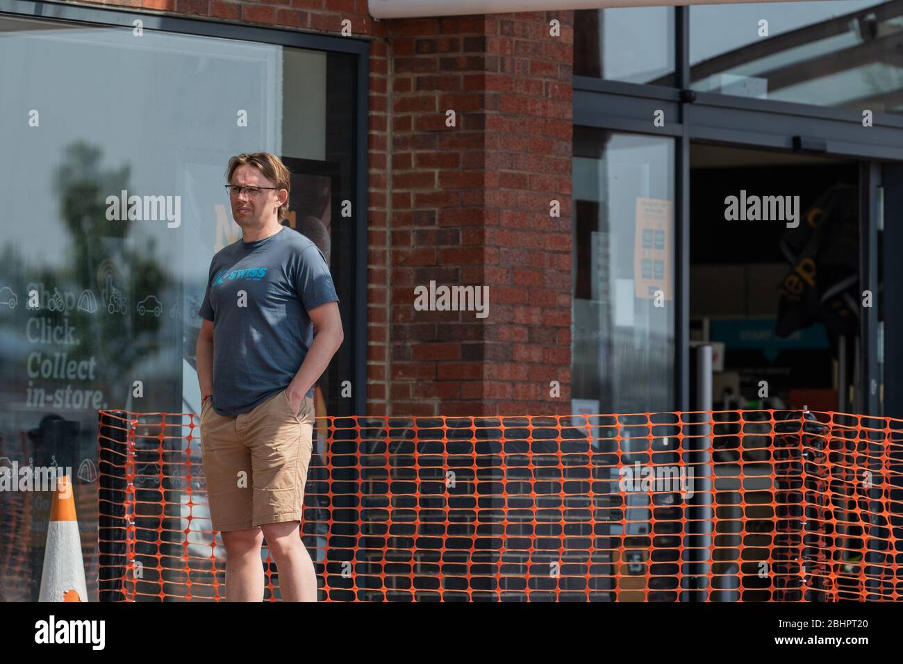 Die Käufer im Gallagher Retail Park stehen während der landesweiten Sperrung des Coronavirus vor langen Warteschlangen vor M&S und B&M. Stockfoto