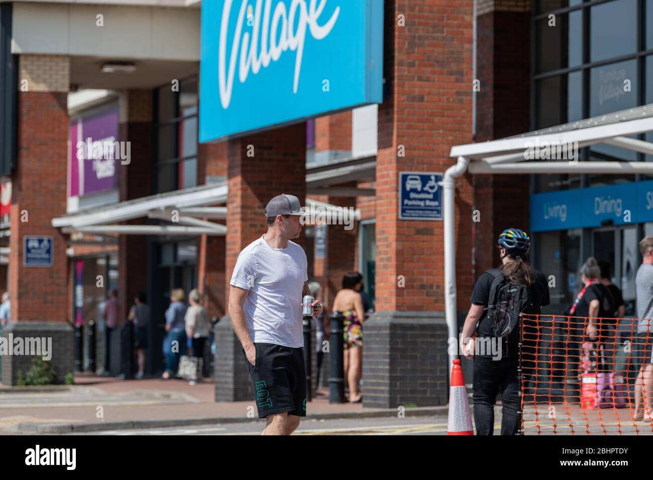 Die Käufer im Gallagher Retail Park stehen während der landesweiten Sperrung des Coronavirus vor langen Warteschlangen vor M&S und B&M. Stockfoto