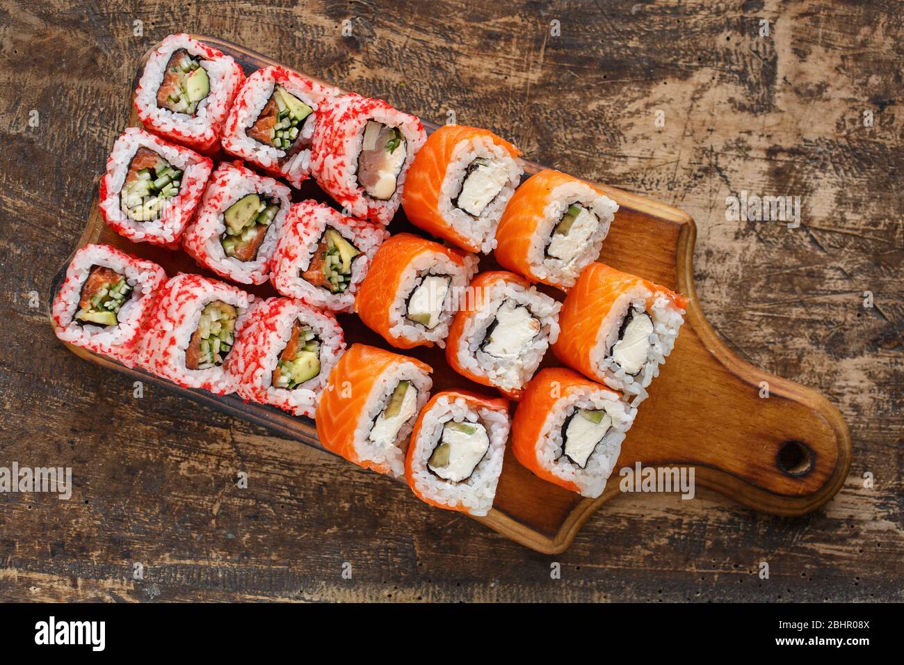 Zwei verschiedene Arten von Sushi-Rollen auf einem Holzbrett. Japanische Küche Stockfoto