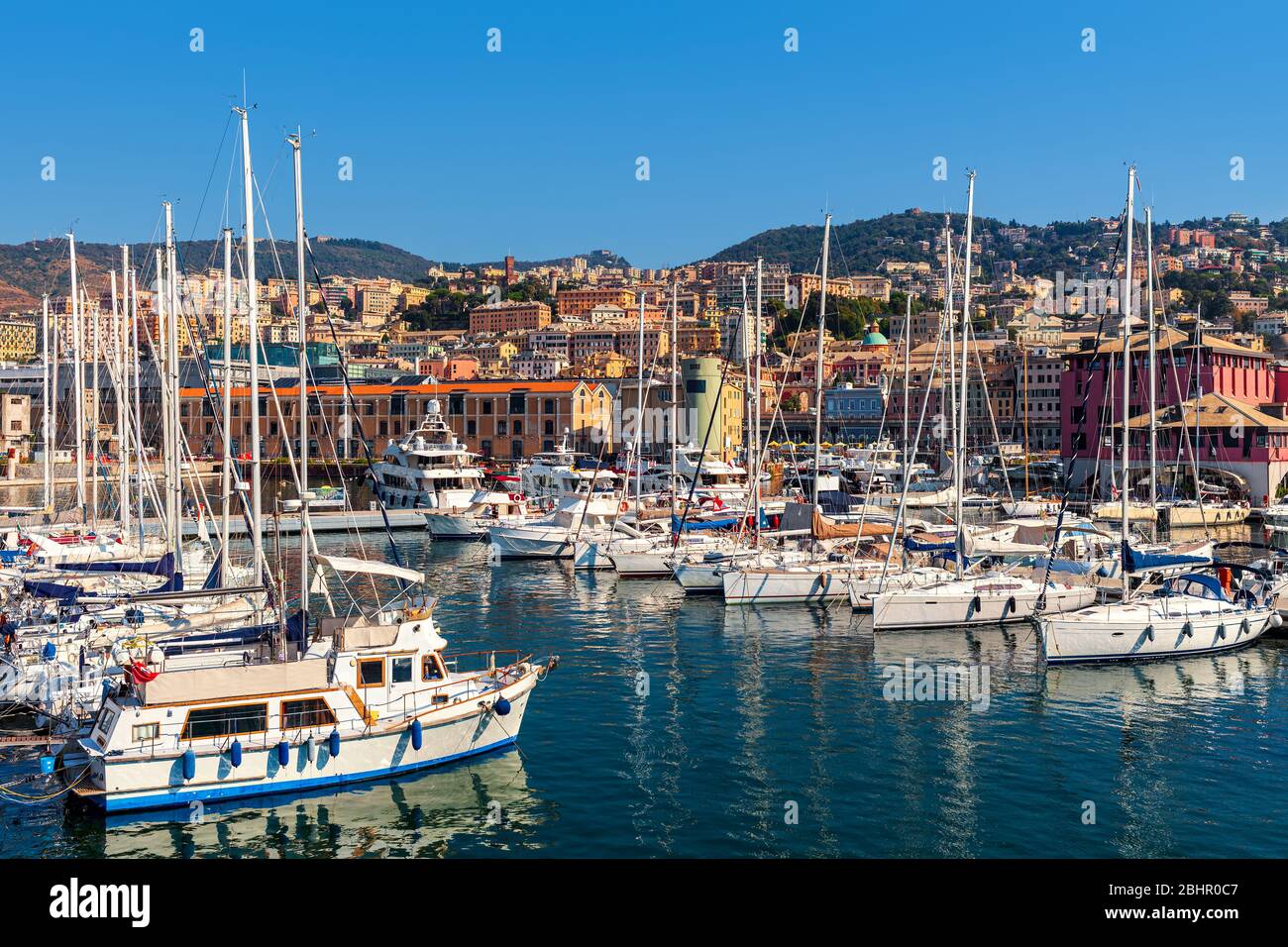 Yachten und Boote in Marina als Stadt Genua auf Hintergrund unter blauem Himmel in Ligurien, Italien. Stockfoto