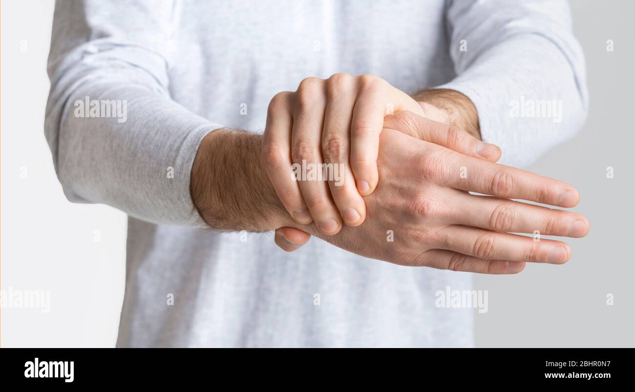 Mann hält seine Hand und fühlt starke Schmerzen Stockfoto