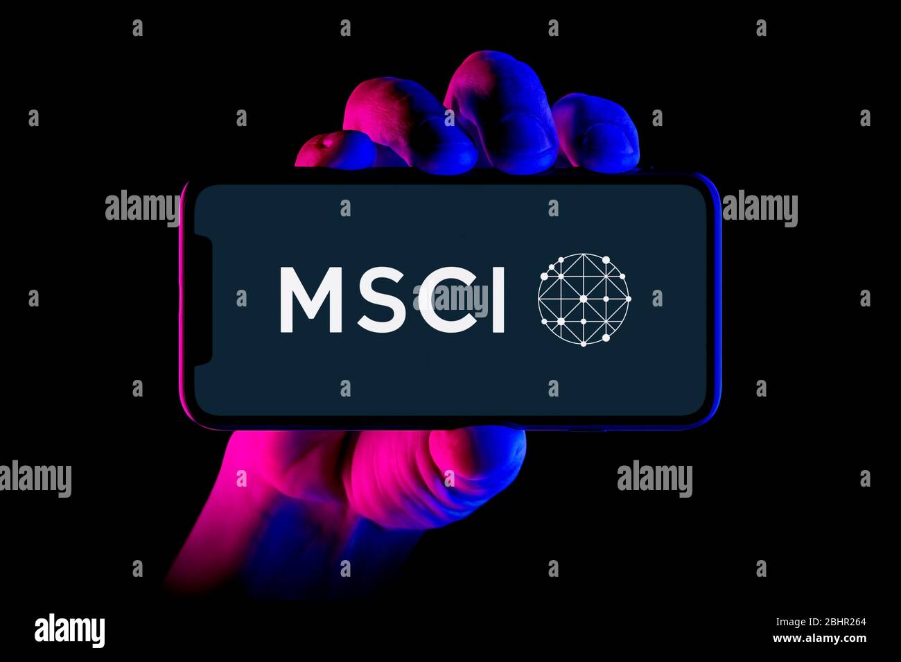 Ein Smartphone mit dem MSCI-Logo wird von einer Handaufnahme auf schwarzem Hintergrund gehalten (nur redaktionelle Verwendung). Stockfoto