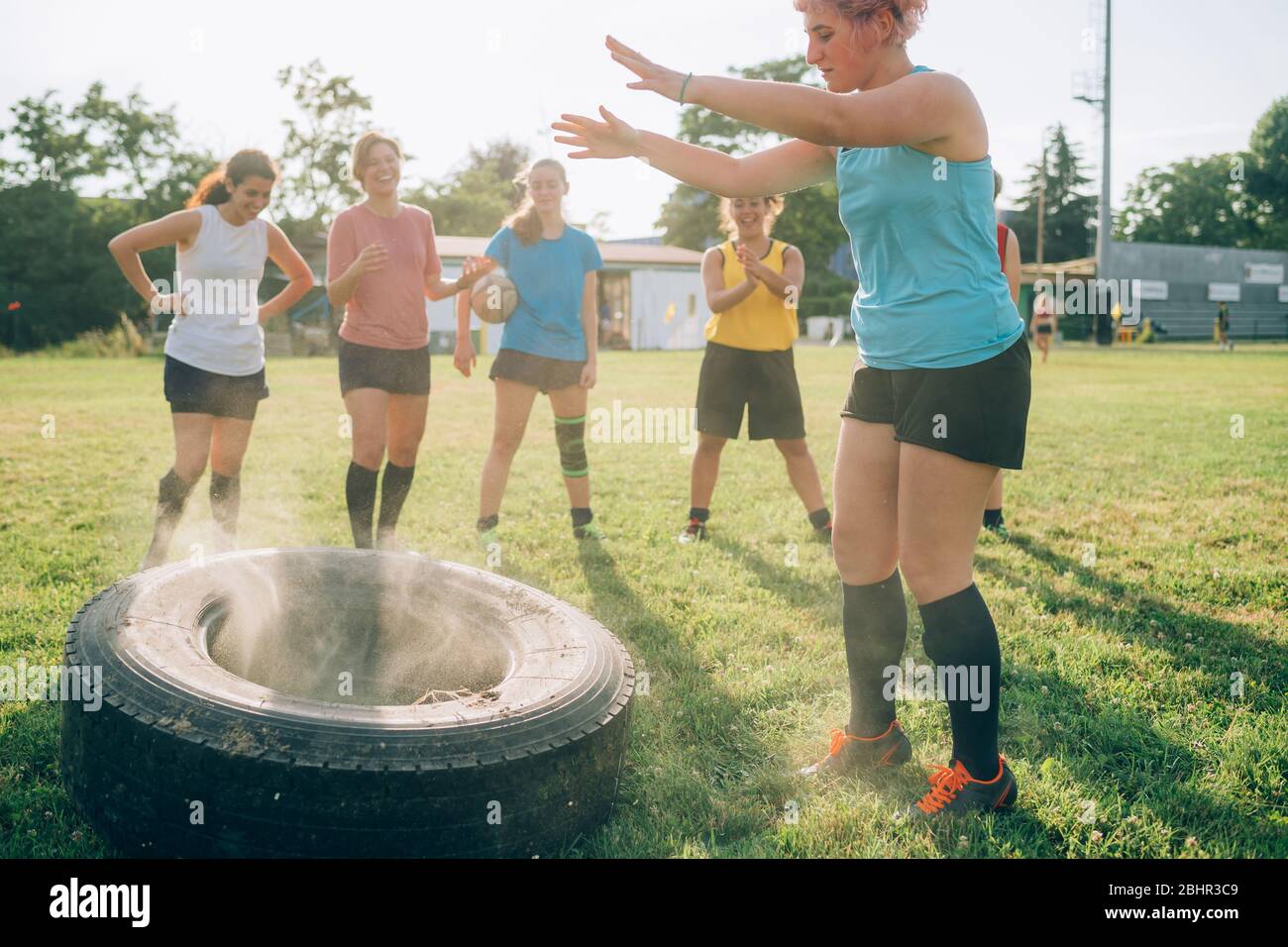 Sechs Frauen beim Rugby Training, eine davon hat gerade einen Reifen geworfen. Stockfoto