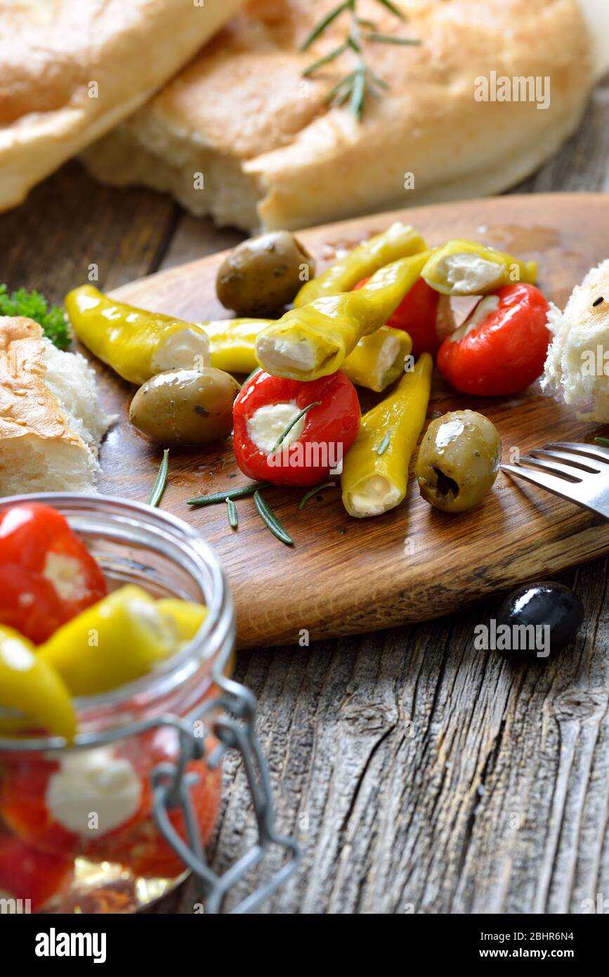 Griechischer Snack: Kirschpaprika und Chili gefüllt mit Frischkäse, serviert mit Oliven und frischem Pita-Brot Stockfoto
