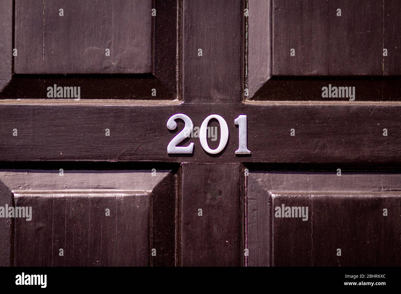 Hausnummer 201 auf einer schwarzen Holztür Stockfoto