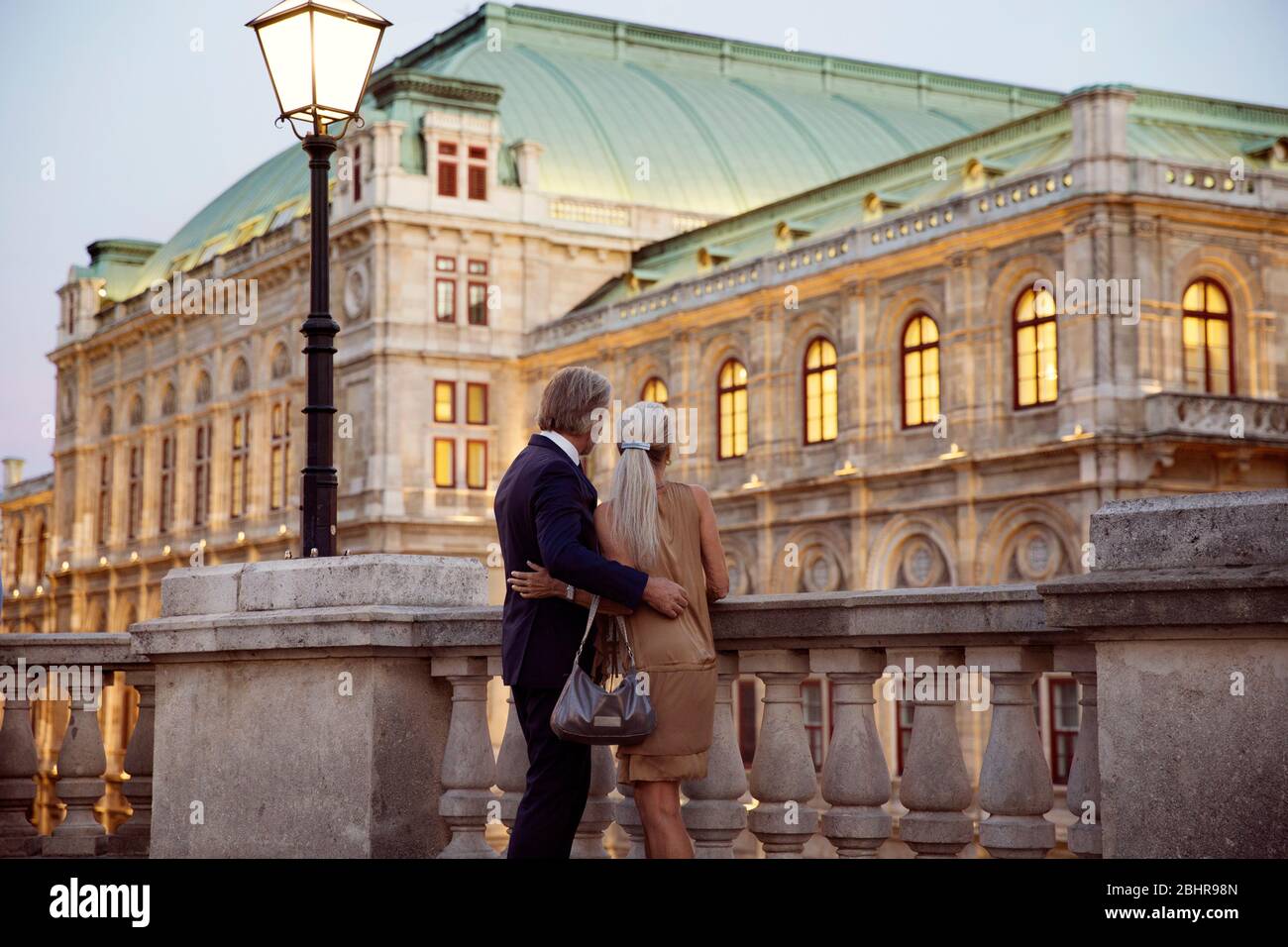 Rückansicht eines Paares, das über eine Balustrade auf eine Wiener Straße blickt. Stockfoto