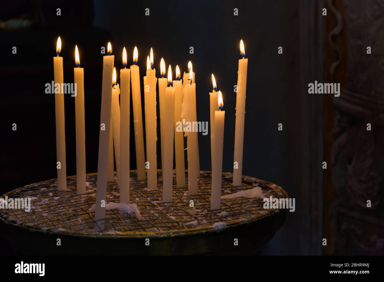 Votivkerzen brennen in einer römisch-katholischen Kirche. Basilica di Santa Maria in Trastevere in Rom, Italien. Stockfoto