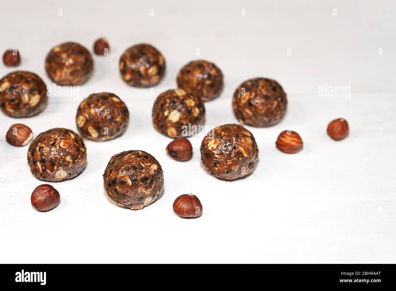Energiekugeln mit Hafer, Schokolade und Nüssen auf grauem Holzhintergrund. Gesunde vegane und rohe Ernährung. Richtige Ernährung Konzept. Selektiver Fokus. Kopierbereich. Stockfoto