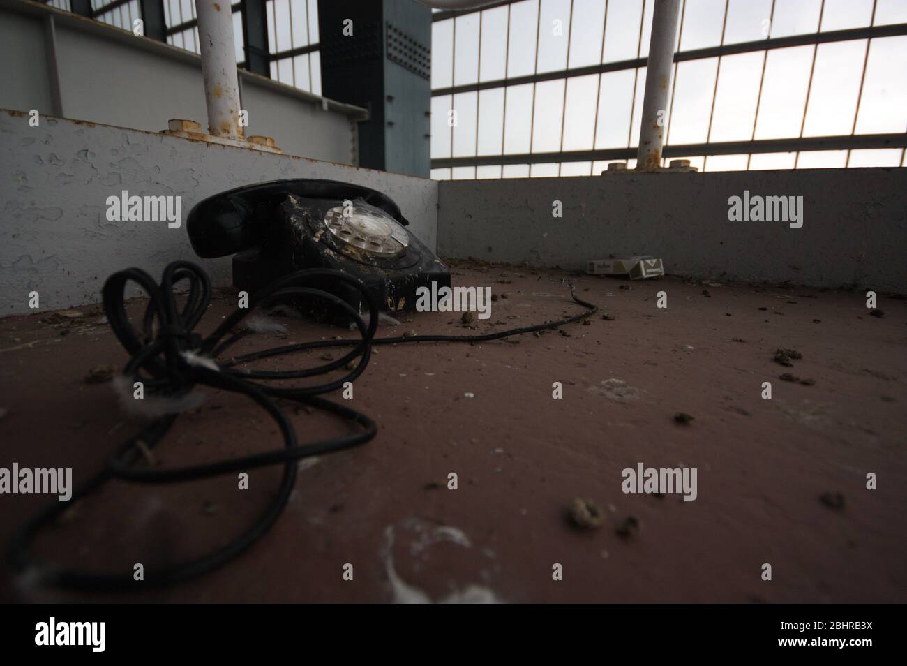 Telefon mit Drehknopf auf dem Boden in verlassenen Kraftwerk urbex Telefongeschichte Vergangenheit verwelkt Stockfoto